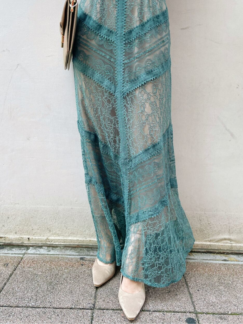 グリーン系のドレス、ベージュ系のパンプス、ブラウン系のクラッチバッグを着用したレディースの夏コーディネートの8枚目の写真