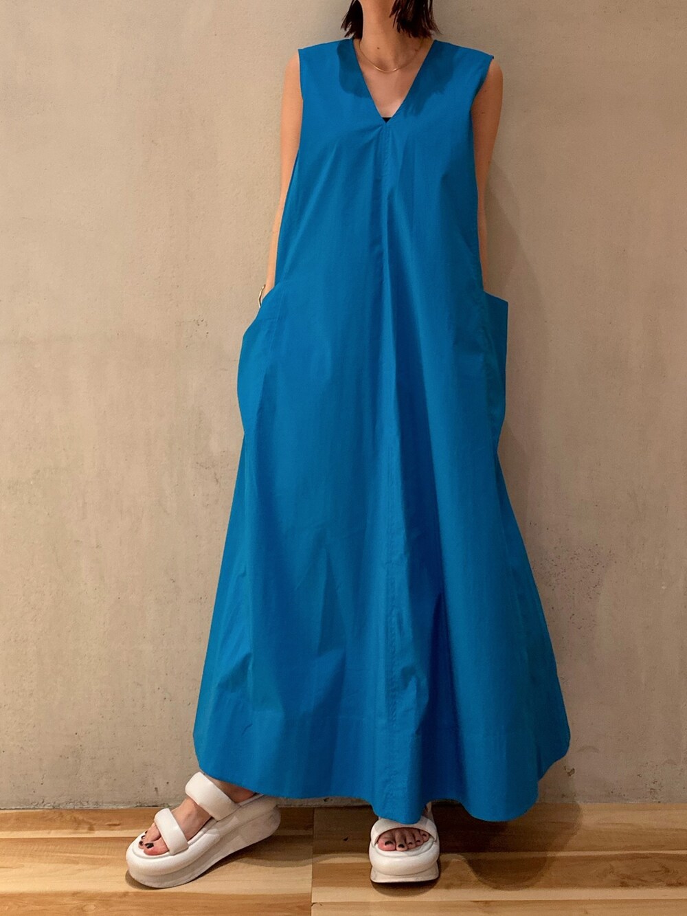 ブルー系のワンピース、ホワイト系のサンダル、ブラック系のブルゾンを着用したレディースの冬コーディネートの2枚目の写真