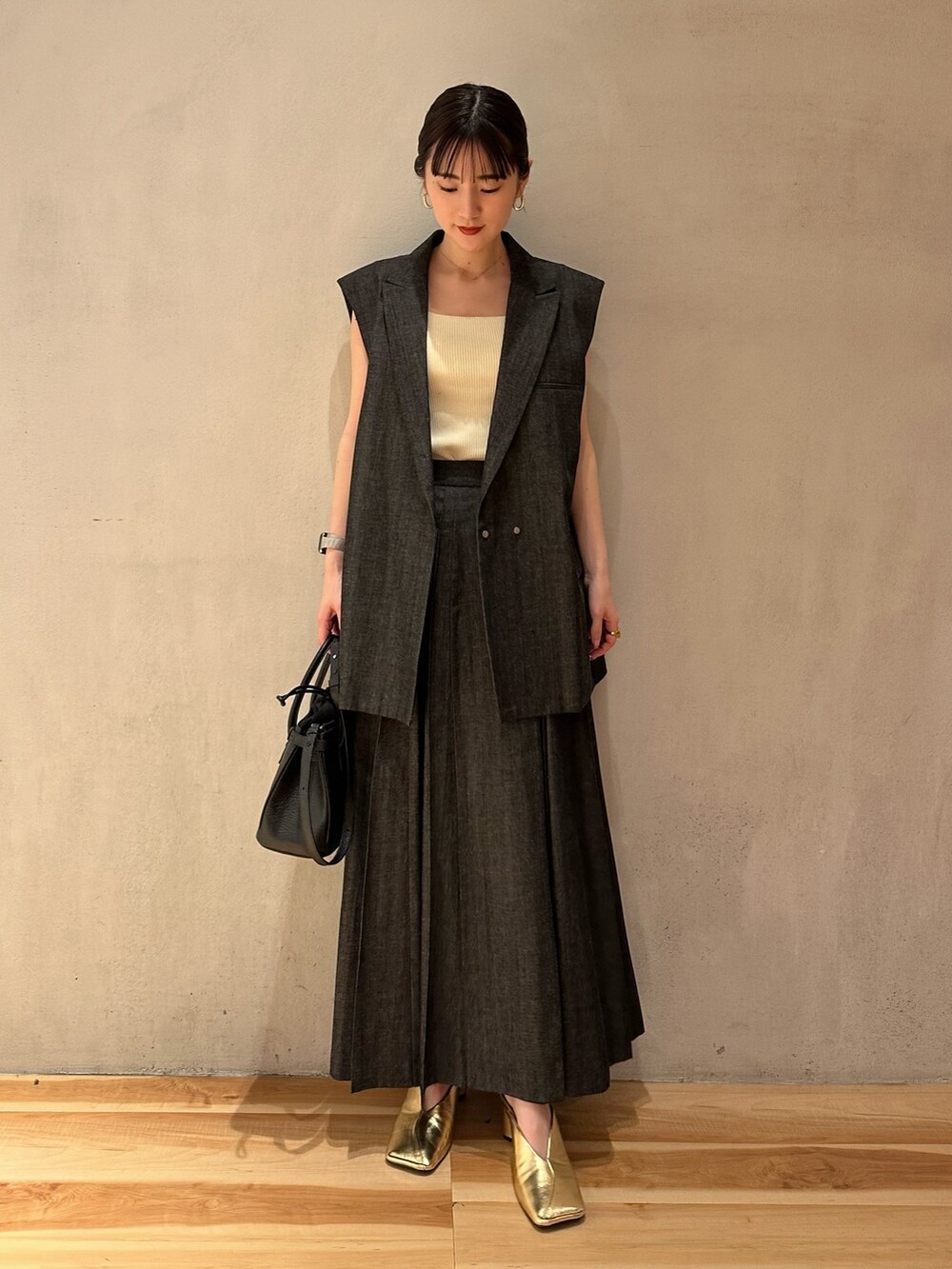 ゴールド系のパンプス、イエロー系のタンクトップ、その他のテーラードジャケットを着用したレディースの春コーディネートの3枚目の写真