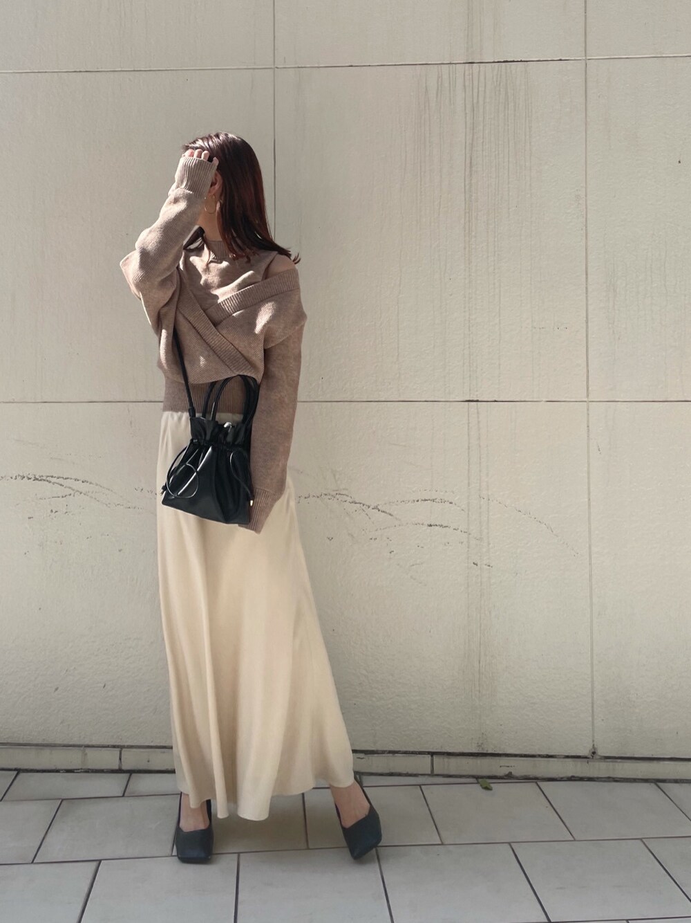 ホワイト系のスカート、ベージュ系のニット/セーターを着用したレディースの冬コーディネートの3枚目の写真