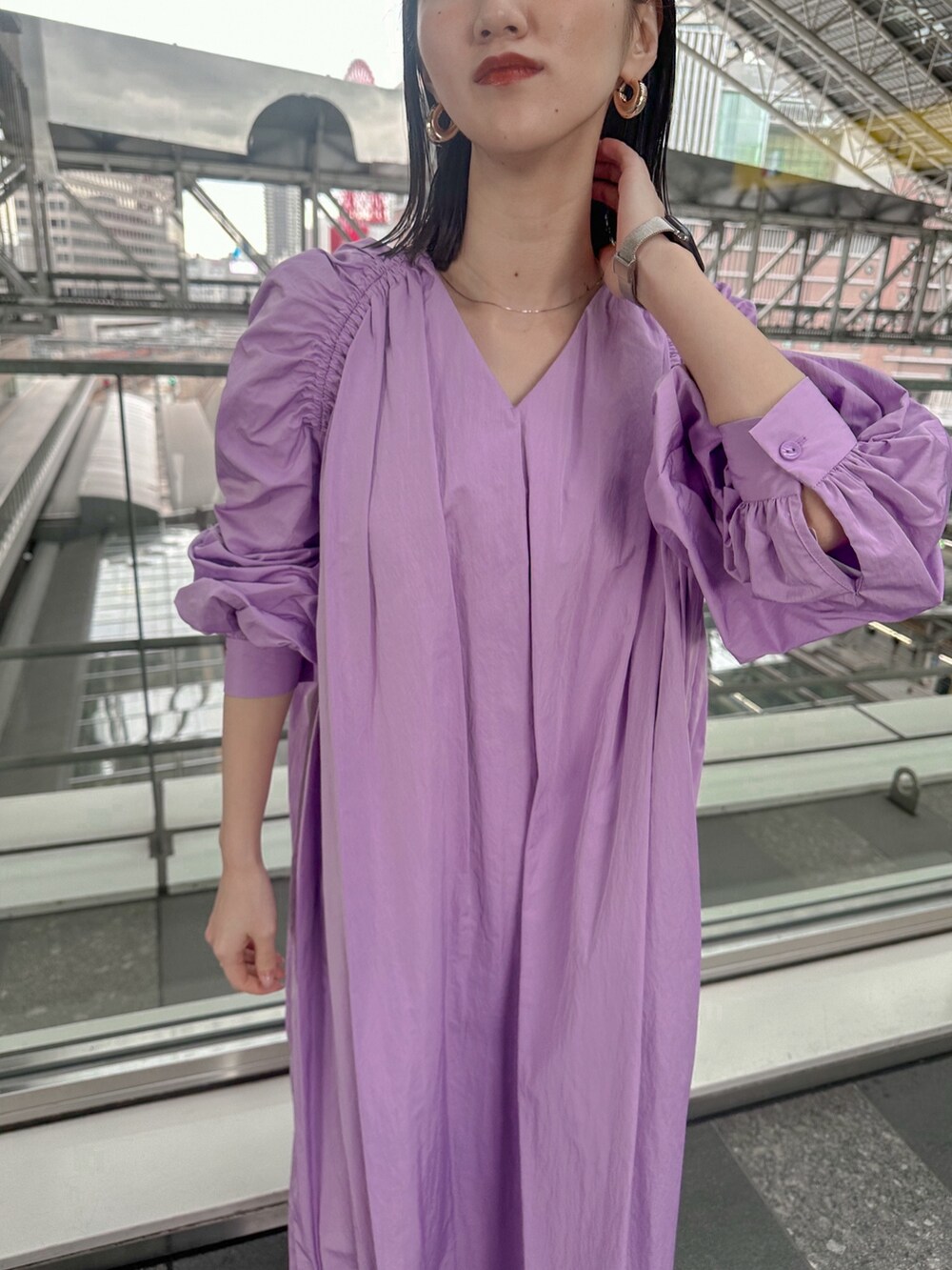 パープル系のワンピース、ブルー系のデニムジャケット、シルバー系のパンプスを着用したレディースの春コーディネートの6枚目の写真