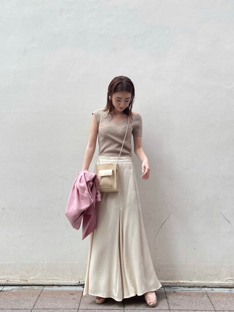 ホワイト系のスカート、その他のパンプス、ベージュ系のハンドバッグを着用したレディースの春コーディネートの2枚目の写真