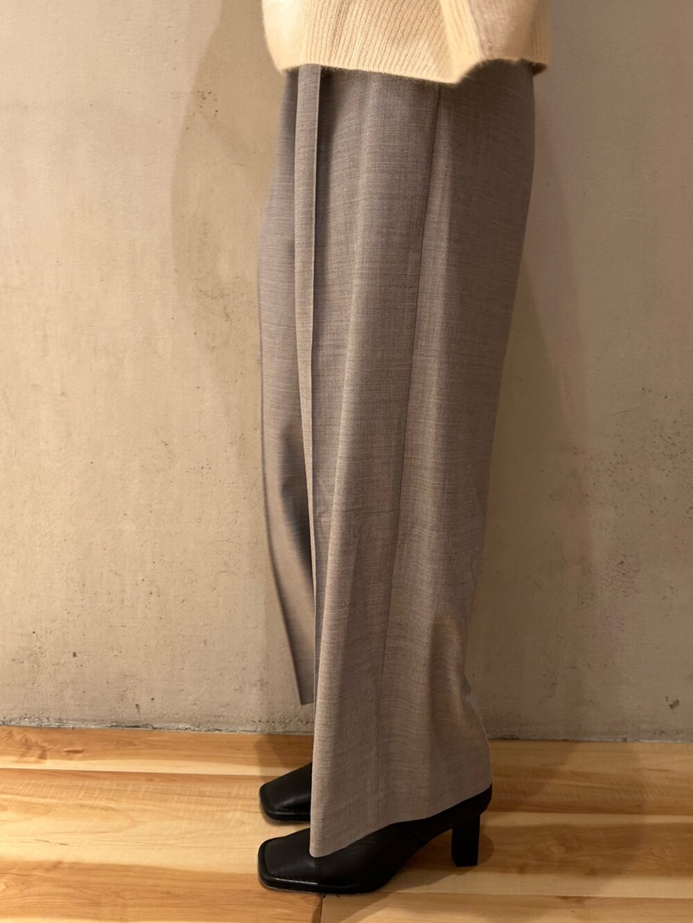 ホワイト系のニット/セーター、グレー系のその他パンツ、ブラック系のブーティを着用したレディースの秋コーディネートの7枚目の写真