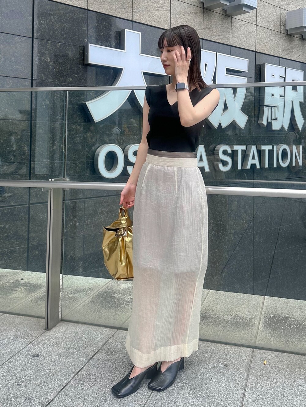 ブラック系のパンプス、ベージュ系のスカート、ブラック系のタンクトップを着用したレディースの夏コーディネートの3枚目の写真