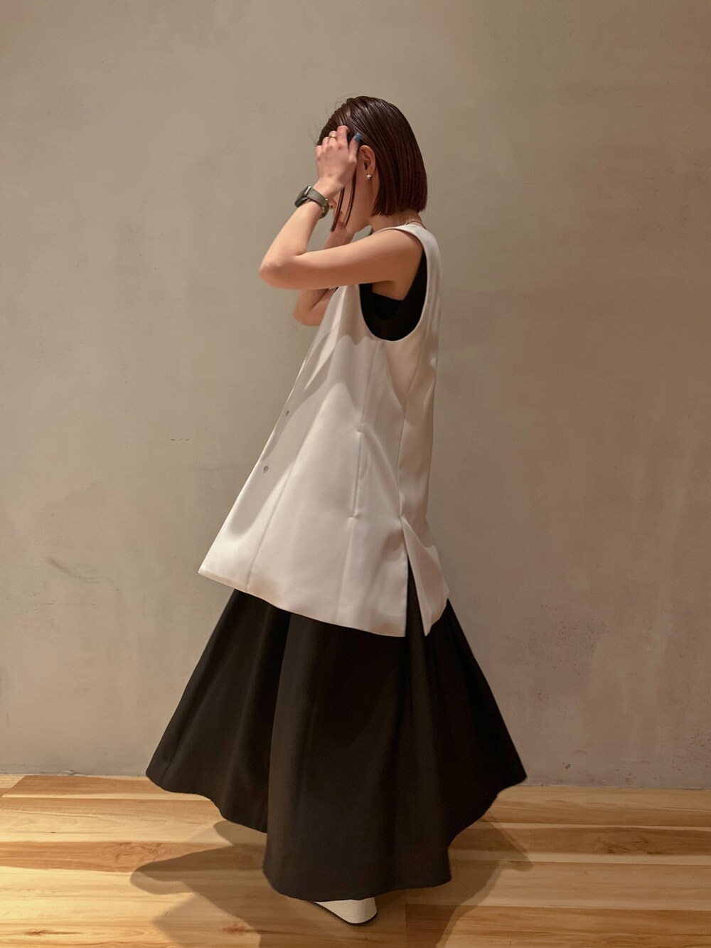 ベージュ系のテーラードジャケット、ブラック系のスニーカー、ブラック系のワンピースを着用したレディースの冬コーディネートの2枚目の写真