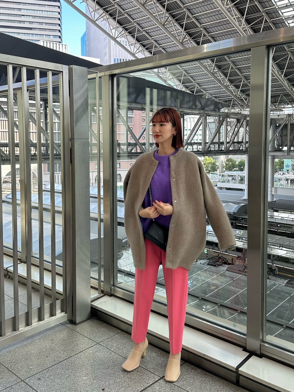 パープル系のニット/セーター、ベージュ系のノーカラージャケット、ブラック系のショルダーバッグを着用したレディースの秋コーディネートの2枚目の写真