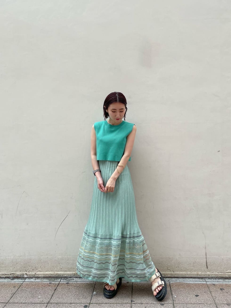 グリーン系のワンピース、ベージュ系のサンダルを着用したレディースの夏コーディネートの4枚目の写真