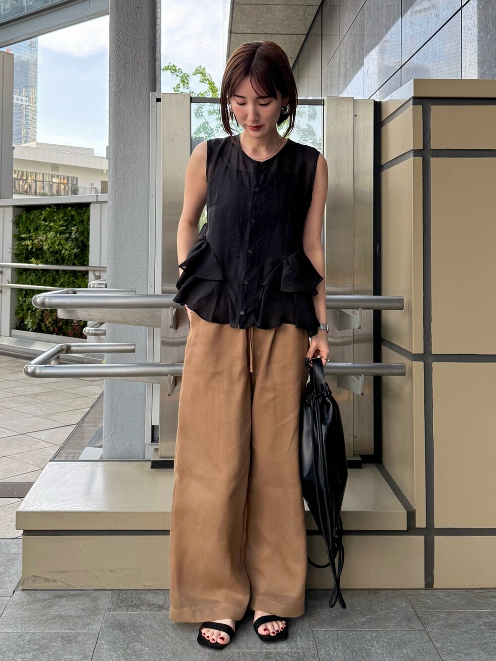 ブラック系のシャツ/ブラウス、ブラウン系のその他パンツ、ブラック系のバックパック/リュックを着用したレディースの春コーディネートの2枚目の写真