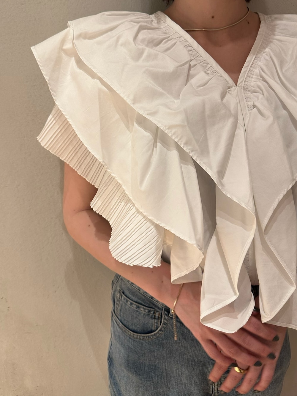 ホワイト系のシャツ/ブラウス、ブラック系のスニーカー、ブルー系のデニムパンツを着用したレディースの春コーディネートの4枚目の写真