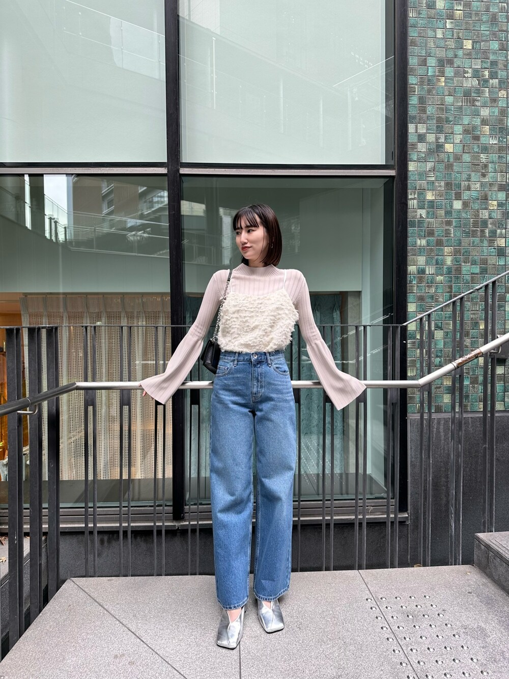 ブルー系のデニムパンツ、ホワイト系のキャミソール、ホワイト系のニット/セーターを着用したレディースの冬コーディネートの5枚目の写真