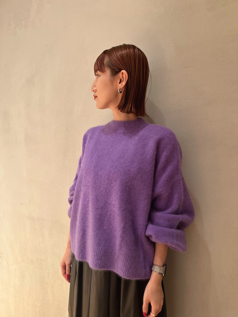 ブラック系のブーツ、ブラック系のジャンパースカート、パープル系のニット/セーターを着用したレディースの秋コーディネートの2枚目の写真