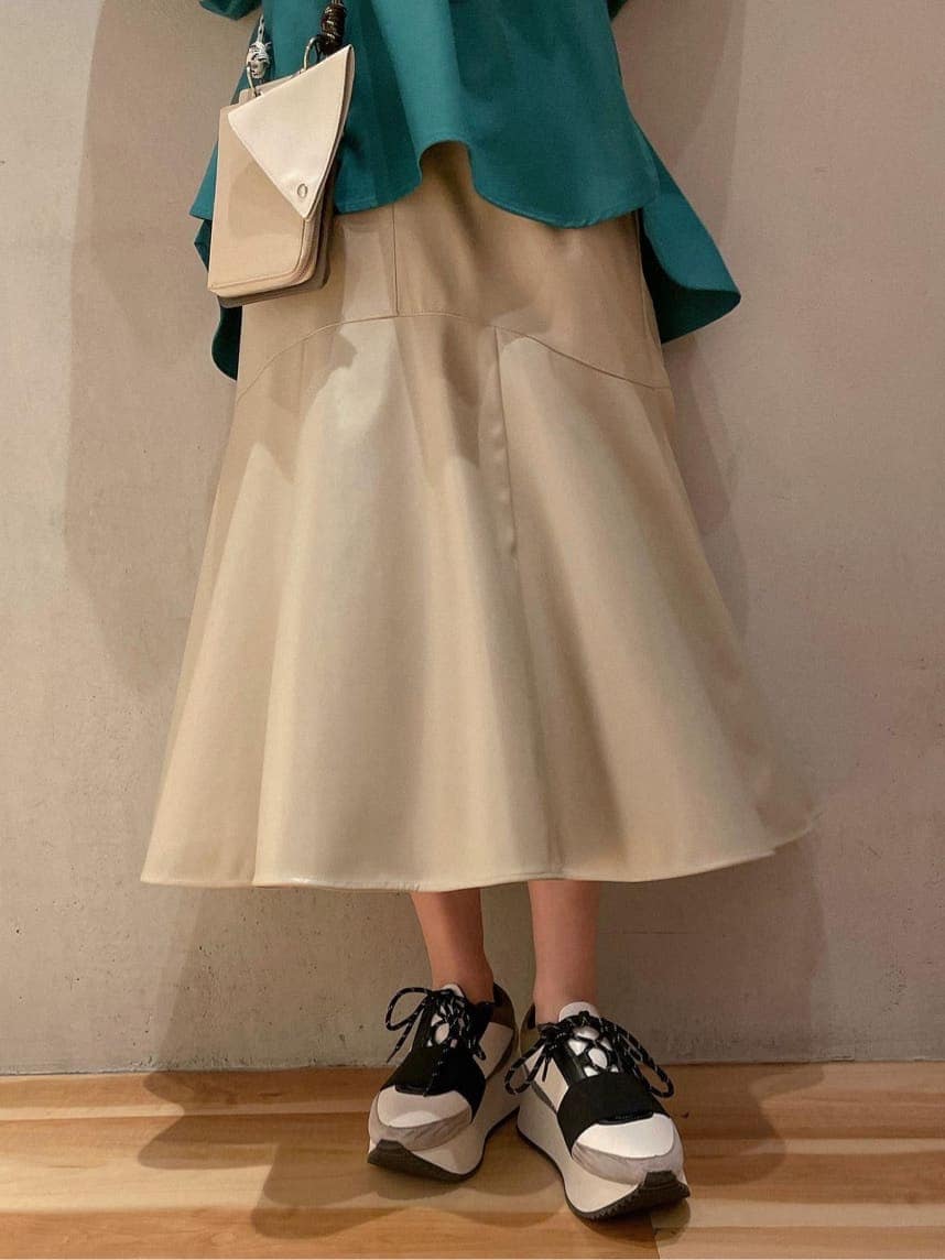 ベージュ系のスカート、ブルー系のスニーカー、グリーン系のシャツ/ブラウスを着用したレディースの秋コーディネートの4枚目の写真