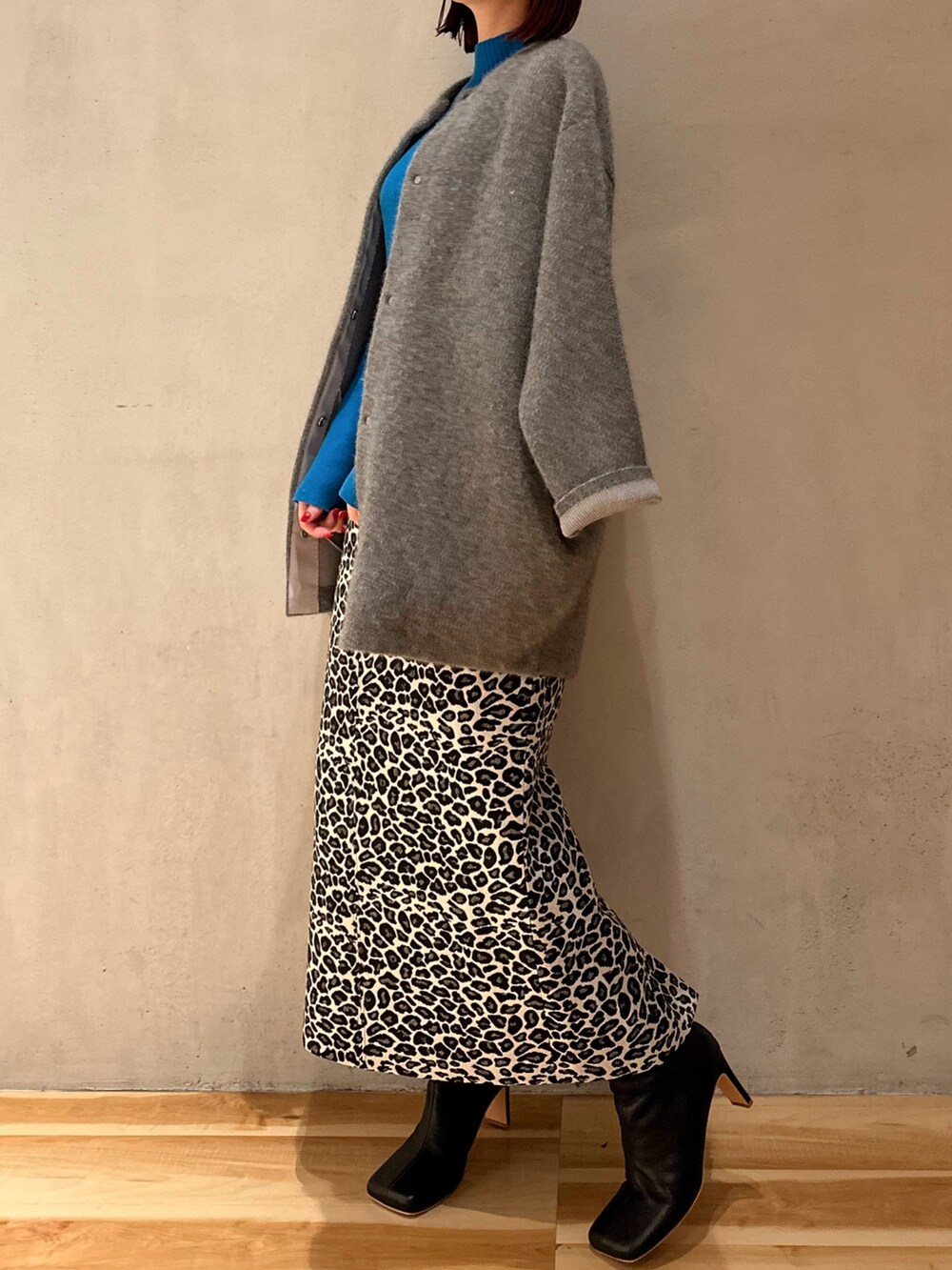 ホワイト系のスカート、ブラック系のブーツ、ブルー系のニット/セーターを着用したレディースの夏コーディネートの3枚目の写真