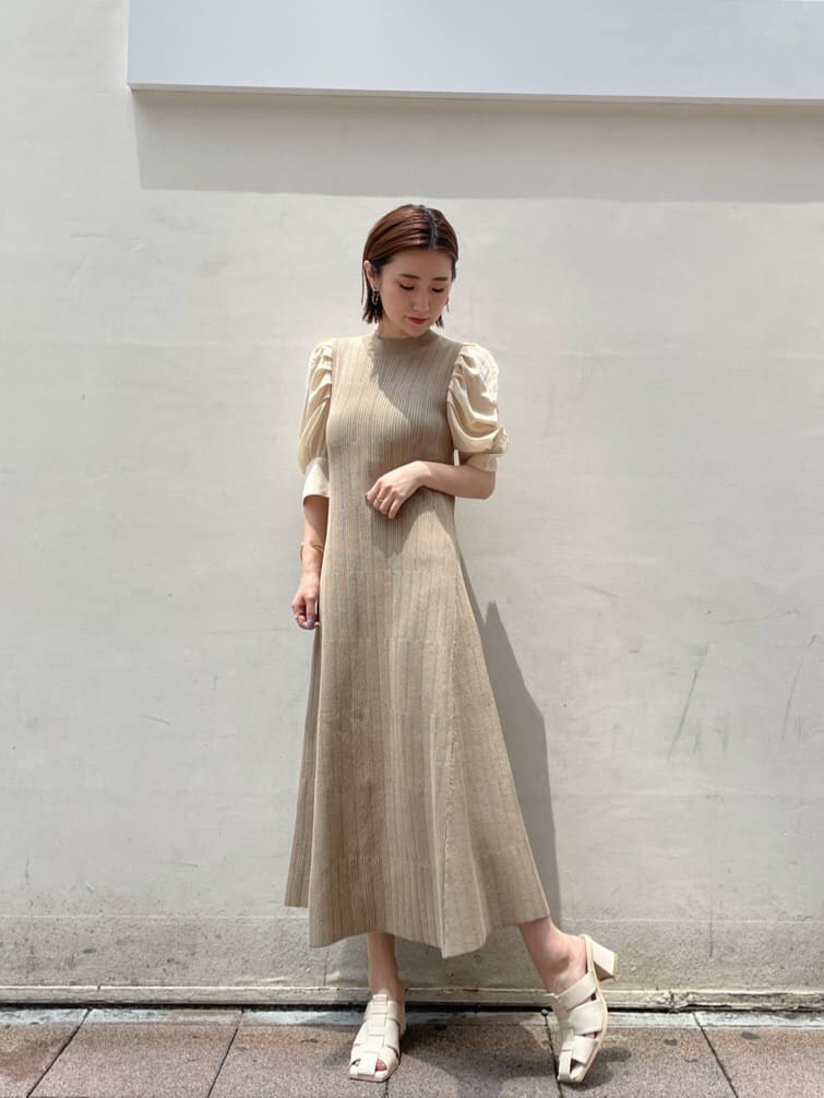 ホワイト系のサンダル、ベージュ系のワンピースを着用したレディースの夏コーディネートの2枚目の写真