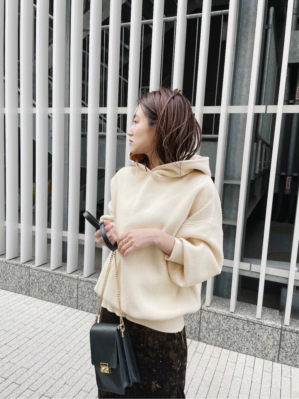 ブラウン系のスカート、ホワイト系のパーカーを着用したレディースの冬コーディネートの3枚目の写真