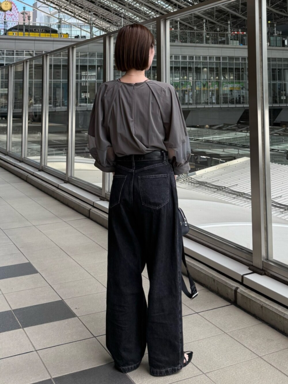 ブラック系のデニムパンツ、グレー系のシャツ/ブラウスを着用したレディースの夏コーディネートの3枚目の写真