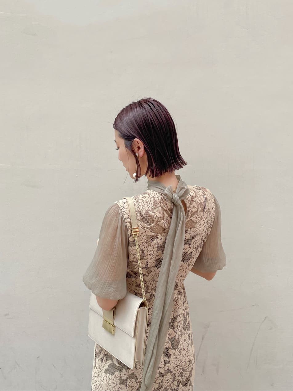 ベージュ系のドレス、ゴールド系のパンプス、ベージュ系のクラッチバッグを着用したレディースの夏コーディネートの7枚目の写真