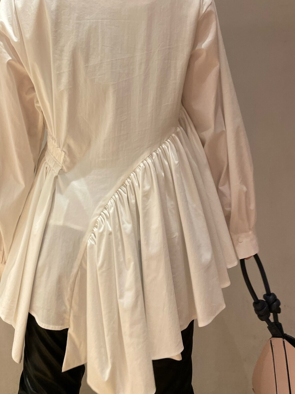 ホワイト系のシャツ/ブラウス、ブラック系のその他パンツ、ベージュ系のハンドバッグを着用したレディースの秋コーディネートの4枚目の写真