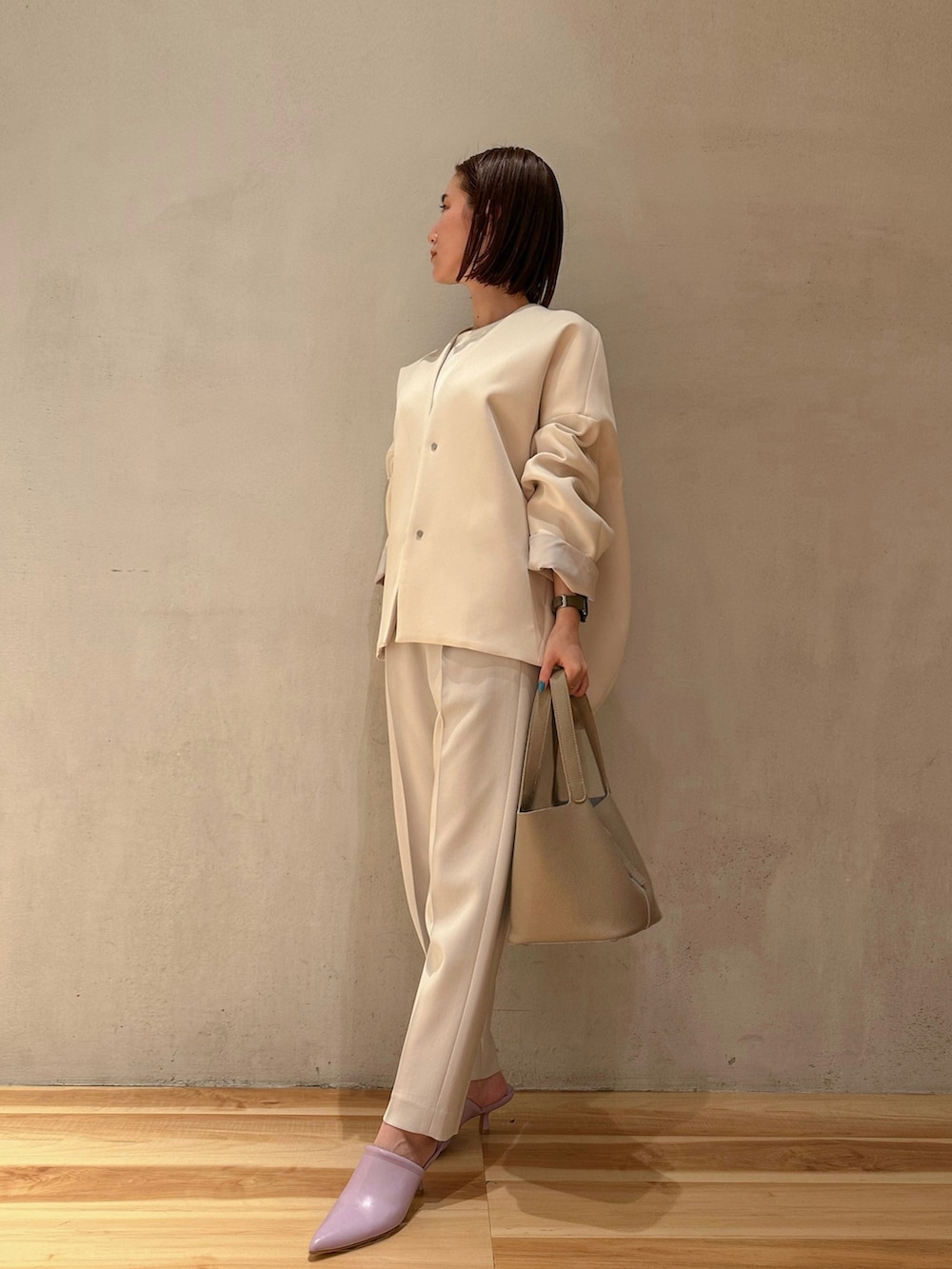 グレー系のその他パンツ、ベージュ系のハンドバッグ、ブラウン系のノーカラーコートを着用したレディースの冬コーディネートの2枚目の写真