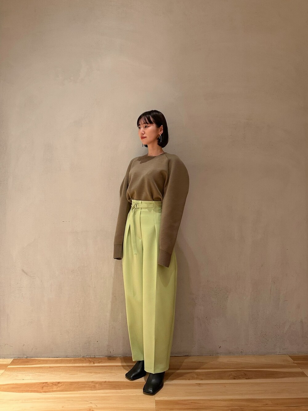 グリーン系のその他パンツ、ベージュ系のニット/セーター、ブラック系のブーティを着用したレディースの冬コーディネートの4枚目の写真