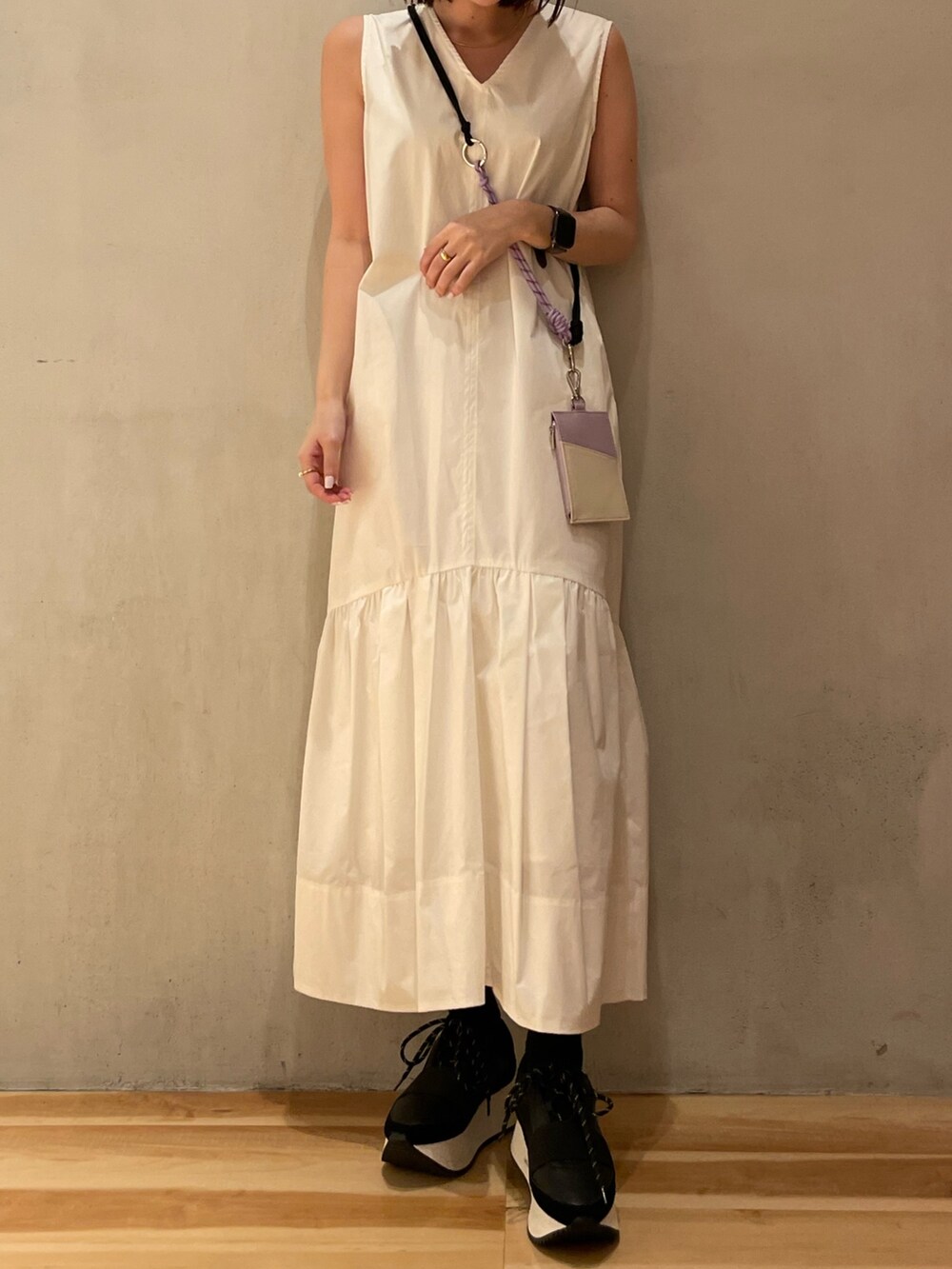 ホワイト系のワンピース、ブラック系のスニーカー、パープル系のスマホケース/カバーを着用したレディースの冬コーディネートの5枚目の写真