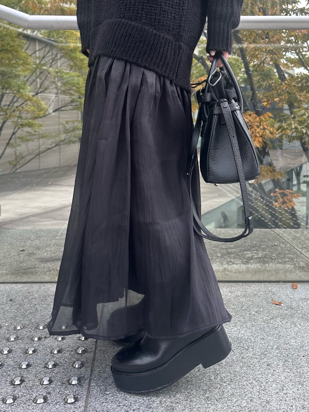 ブラック系のワンピース、ブラック系のショルダーバッグ、ブラック系のキャップを着用したレディースの秋コーディネートの9枚目の写真