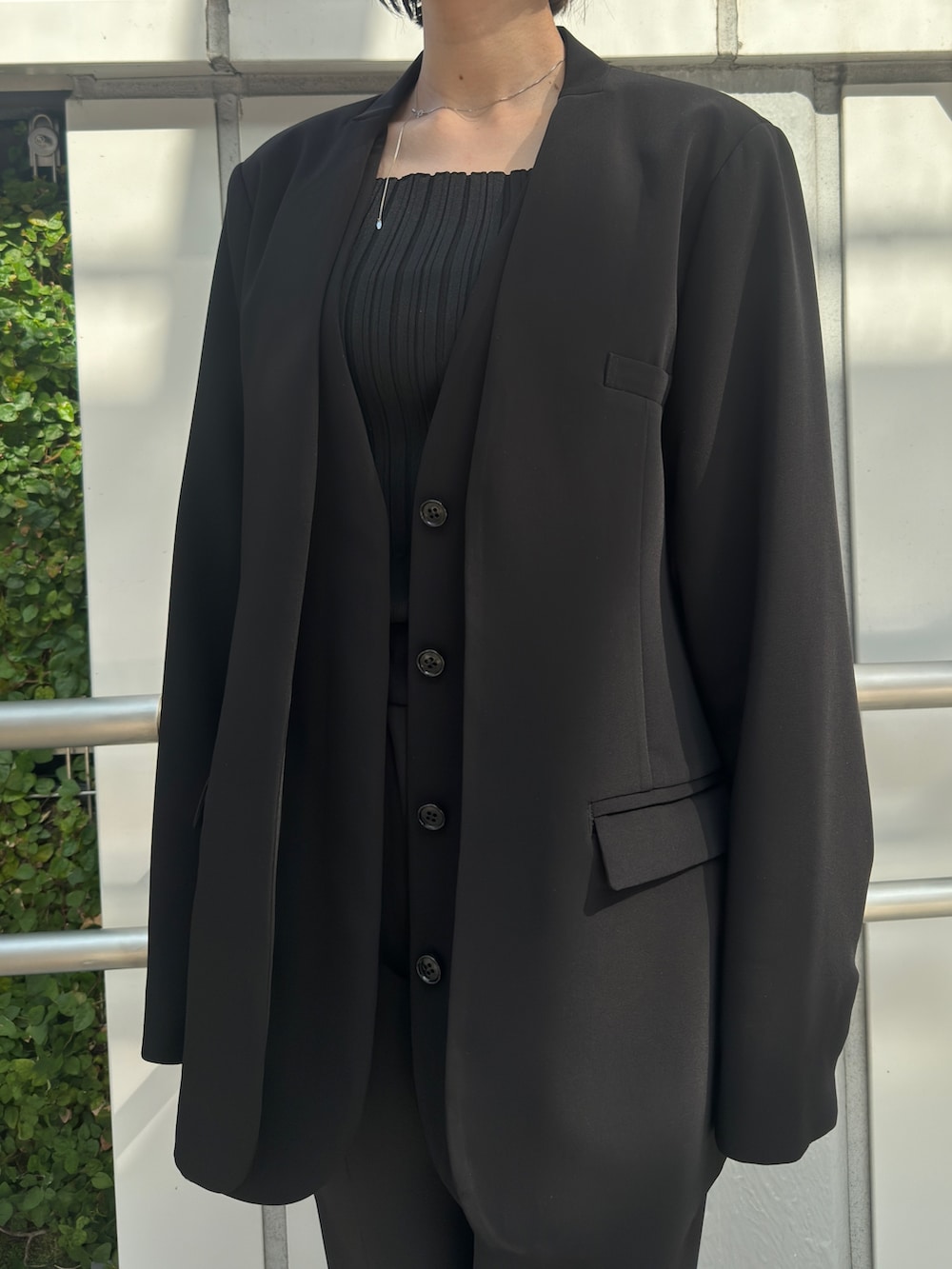 ブラック系のノーカラージャケット、ブラック系のその他パンツ、ブラック系のパンプスを着用したレディースの冬コーディネートの4枚目の写真