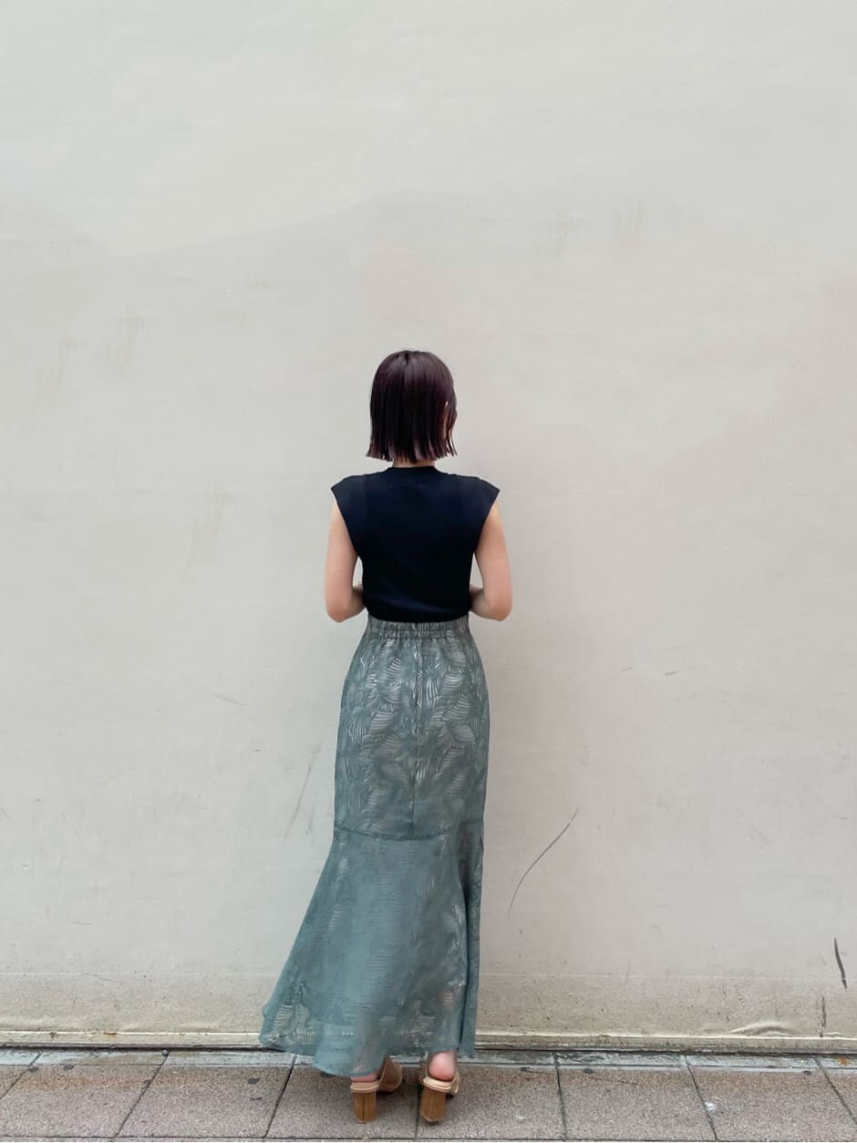 ブルー系のスカート、ベージュ系のサンダル、ブラック系のニット/セーターを着用したレディースの夏コーディネートの6枚目の写真