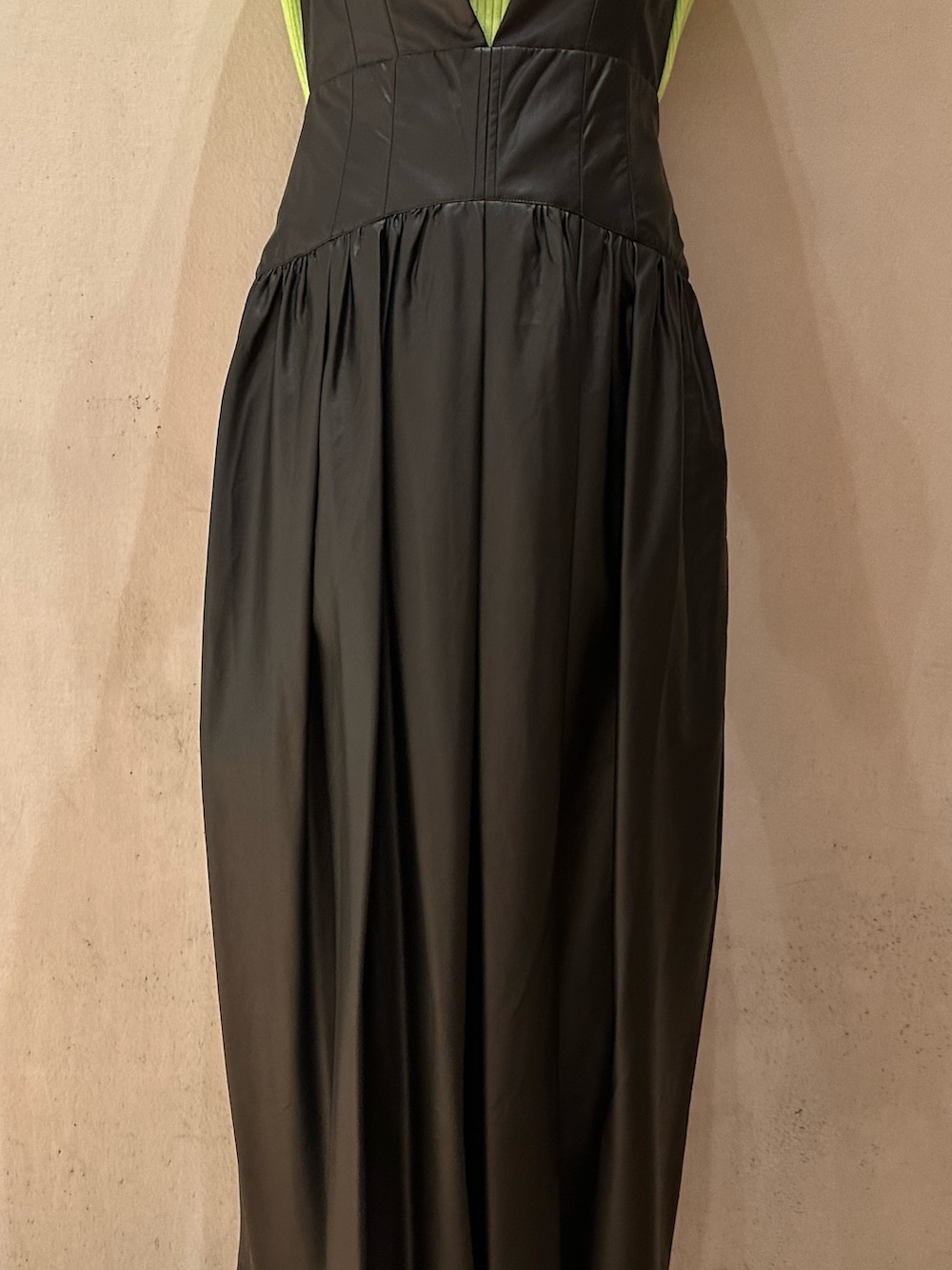 ブラック系のジャンパースカート、ブラック系のブーツ、グリーン系のニット/セーターを着用したレディースの秋コーディネートの7枚目の写真