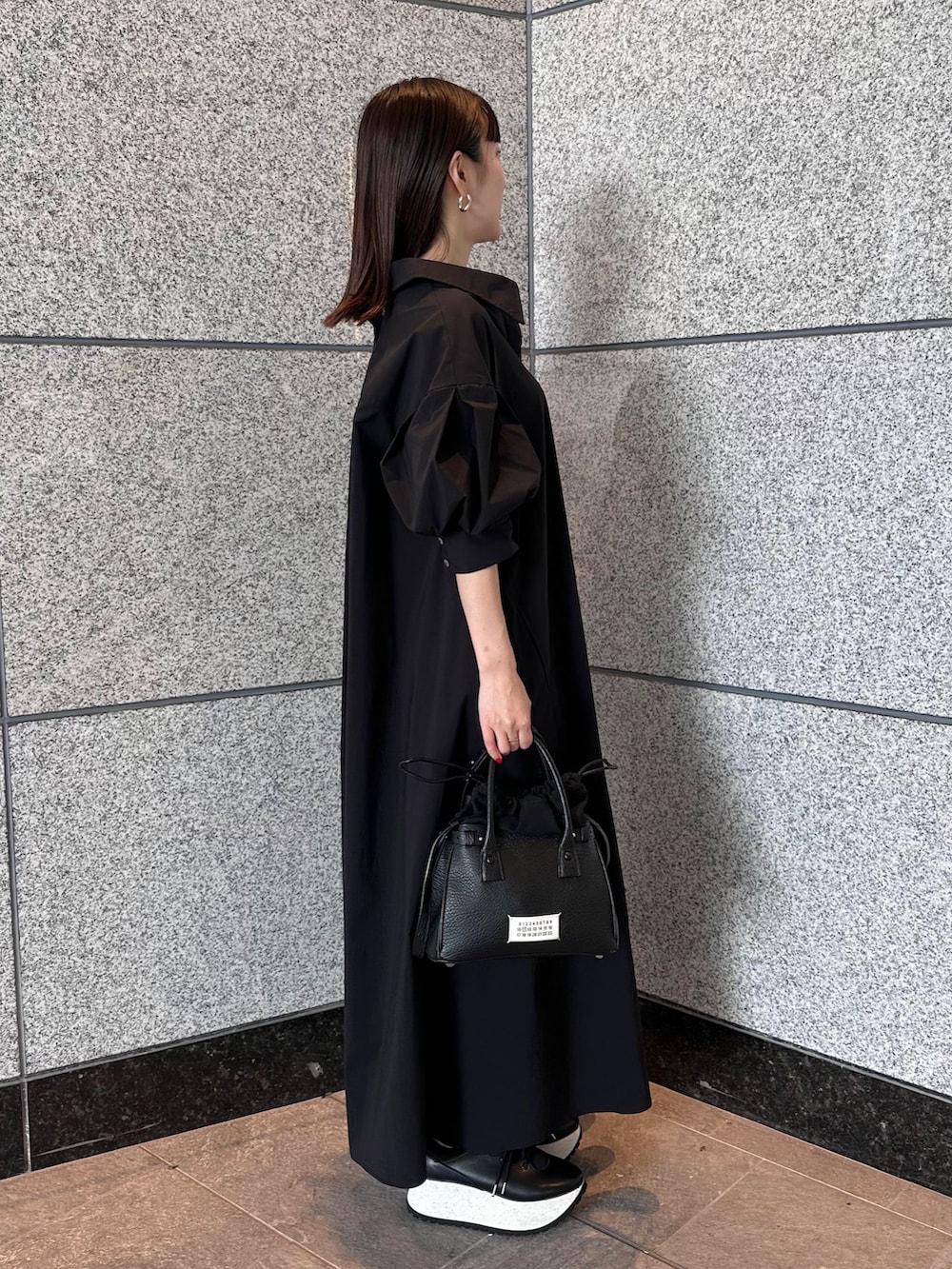 ブラック系のワンピース、ブラック系のスニーカー、ブラック系のショルダーバッグを着用したレディースの夏コーディネートの4枚目の写真