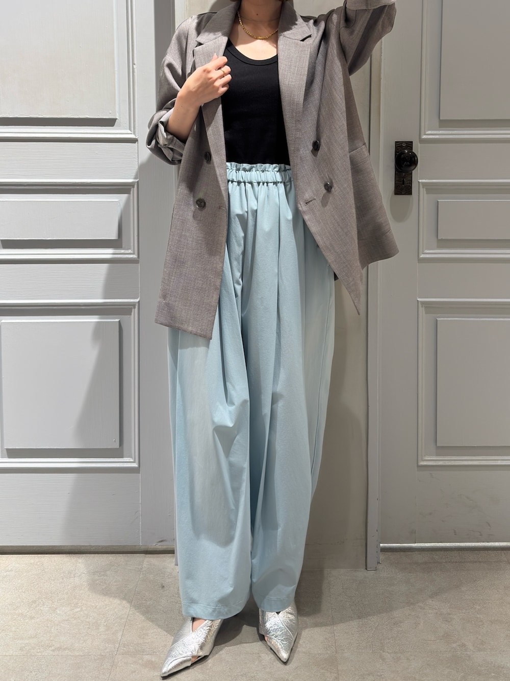 グレー系のテーラードジャケット、グリーン系のその他パンツ、シルバー系のパンプスを着用したレディースの冬コーディネートの2枚目の写真