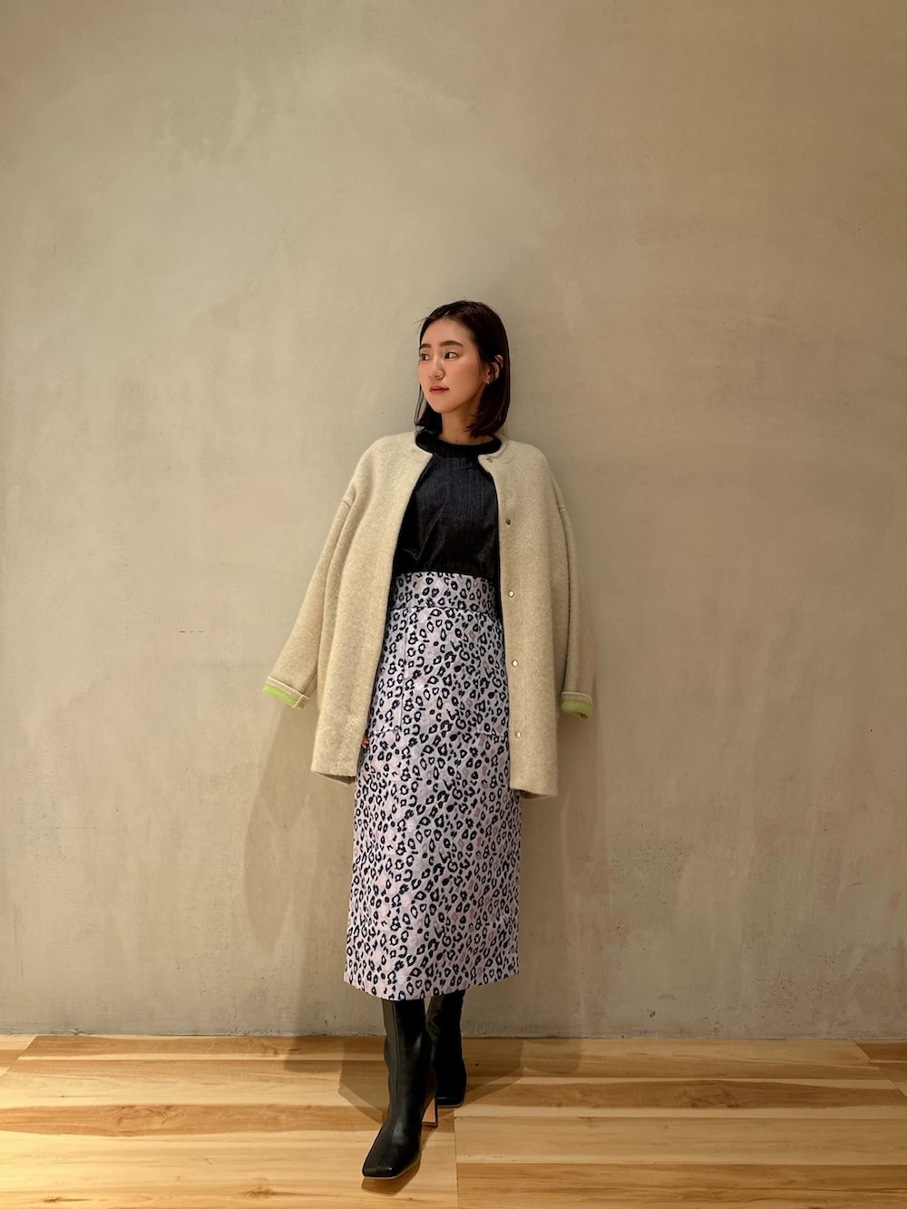 ホワイト系のカーディガン/ボレロ、ブラック系のブーツ、ブルー系のシャツ/ブラウスを着用したレディースの冬コーディネートの2枚目の写真