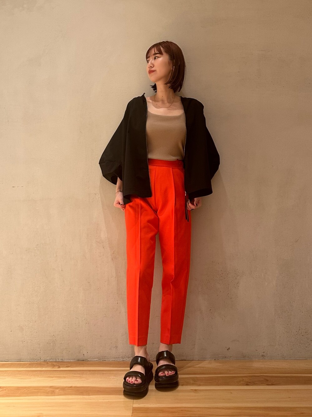 ブラック系のブルゾン、ブラック系のサンダル、ベージュ系のタンクトップを着用したレディースの春コーディネートの2枚目の写真