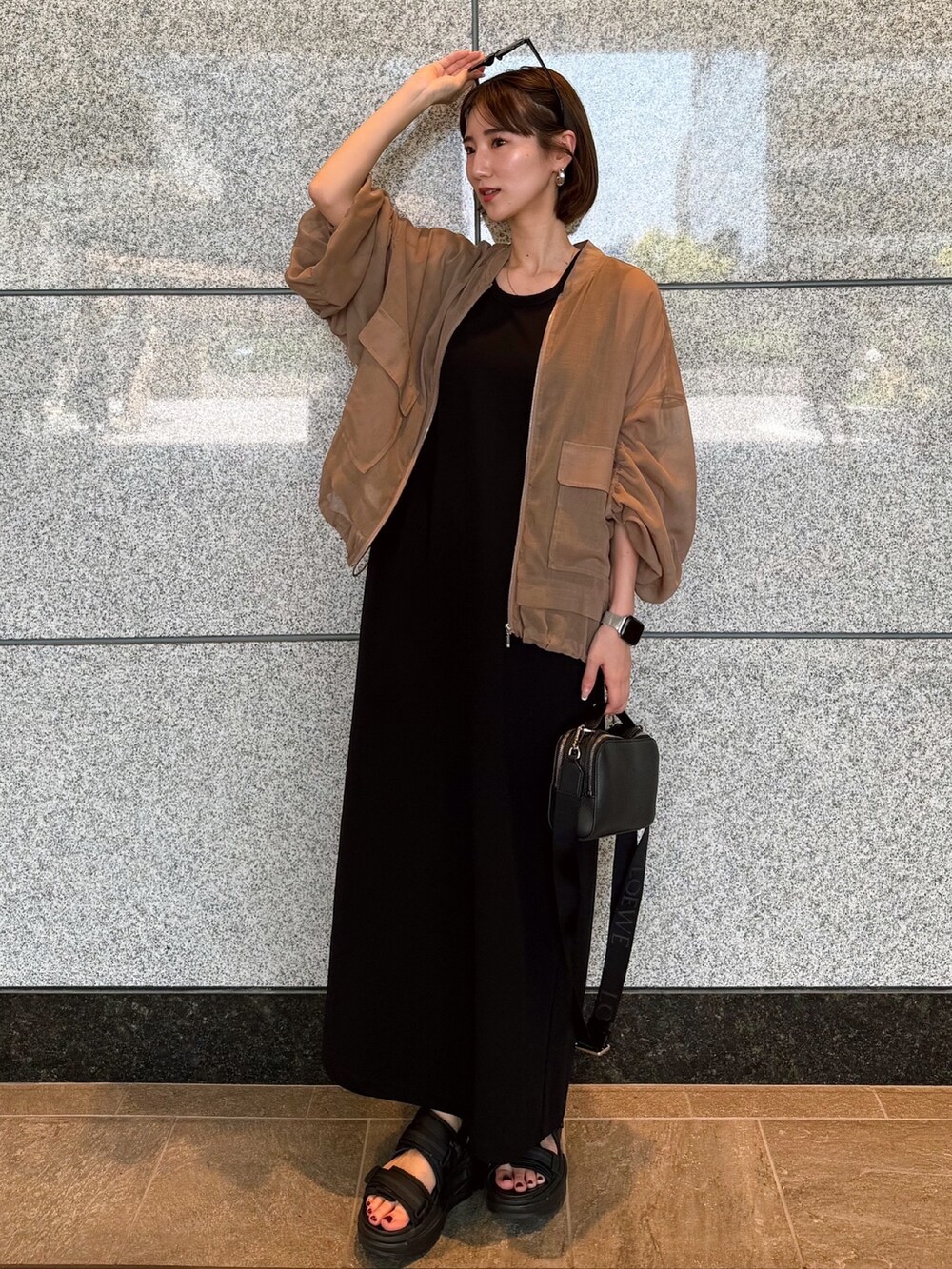 ベージュ系のブルゾン、ブラック系のワンピース、ブラック系のサングラスを着用したレディースの夏コーディネートの5枚目の写真