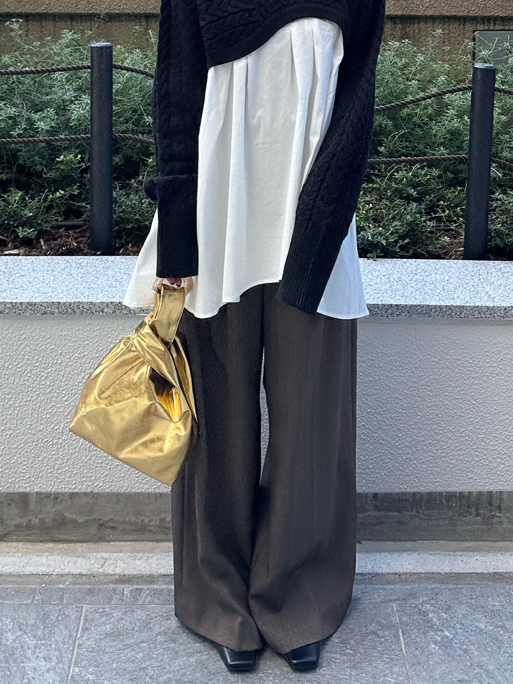 ブラック系のニット/セーター、ブラウン系のその他パンツ、ゴールド系のハンドバッグを着用したレディースの秋コーディネートの8枚目の写真