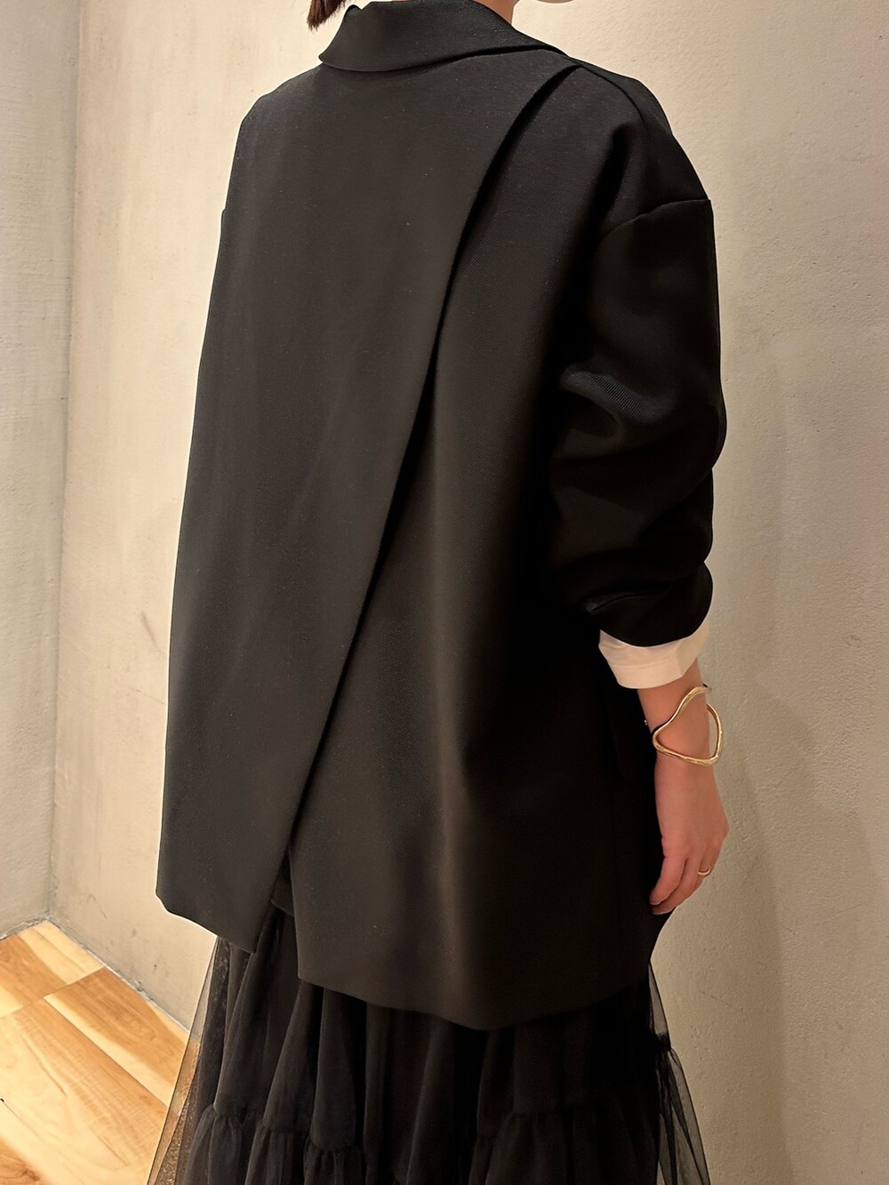 ブラック系のスカート、ブラック系のテーラードジャケット、ホワイト系のTシャツ/カットソーを着用したレディースの冬コーディネートの6枚目の写真