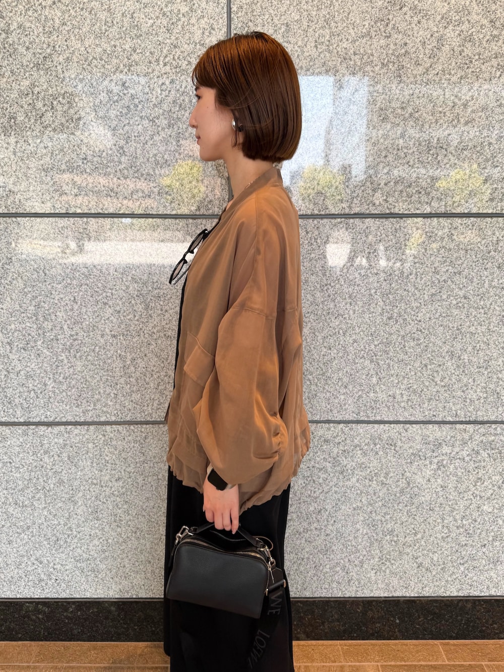 ベージュ系のブルゾン、ブラック系のワンピース、ブラック系のサングラスを着用したレディースの夏コーディネートの6枚目の写真