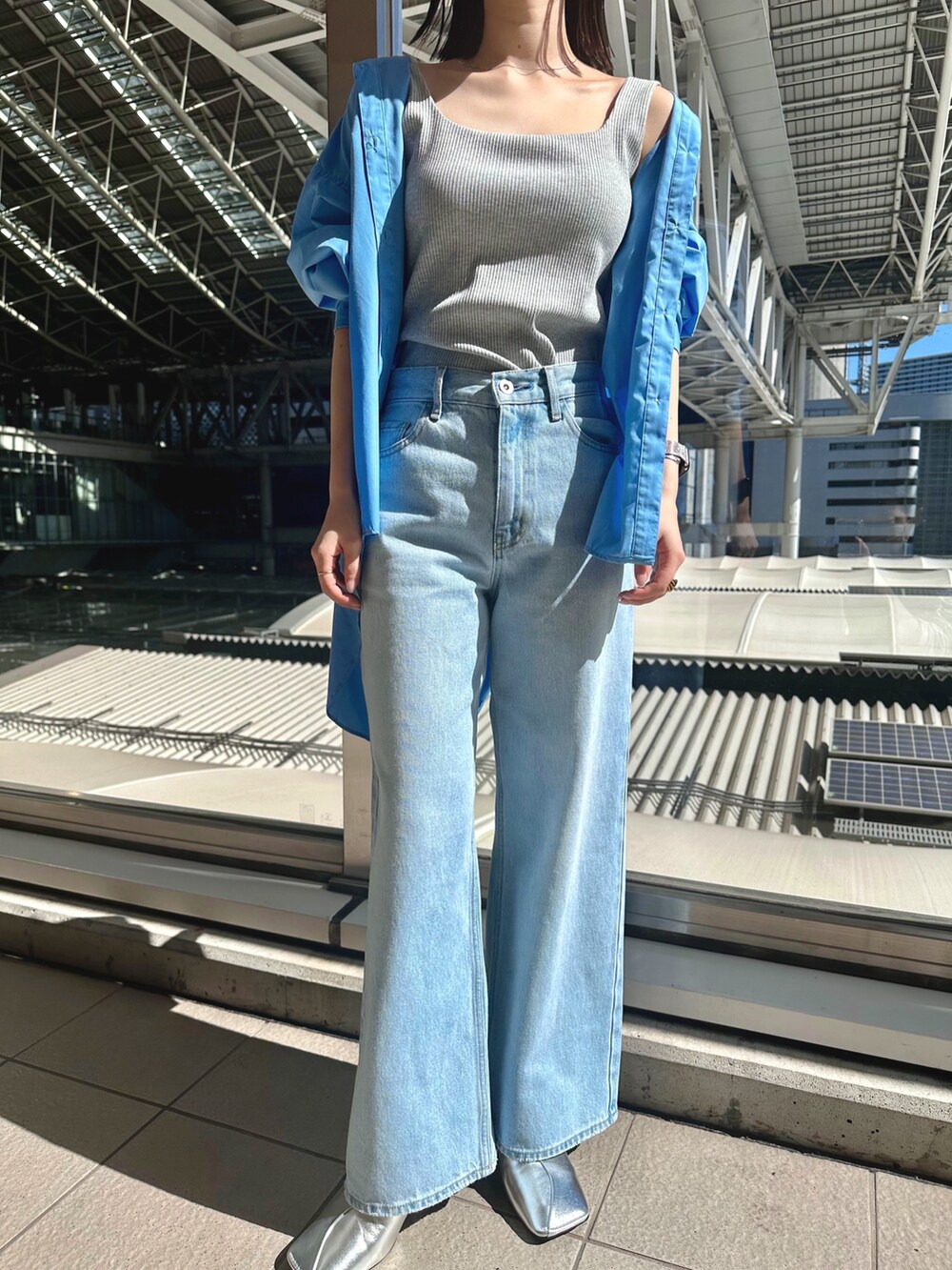 ブルー系のデニムパンツ、シルバー系のパンプス、グレー系のタンクトップを着用したレディースの春コーディネートの2枚目の写真