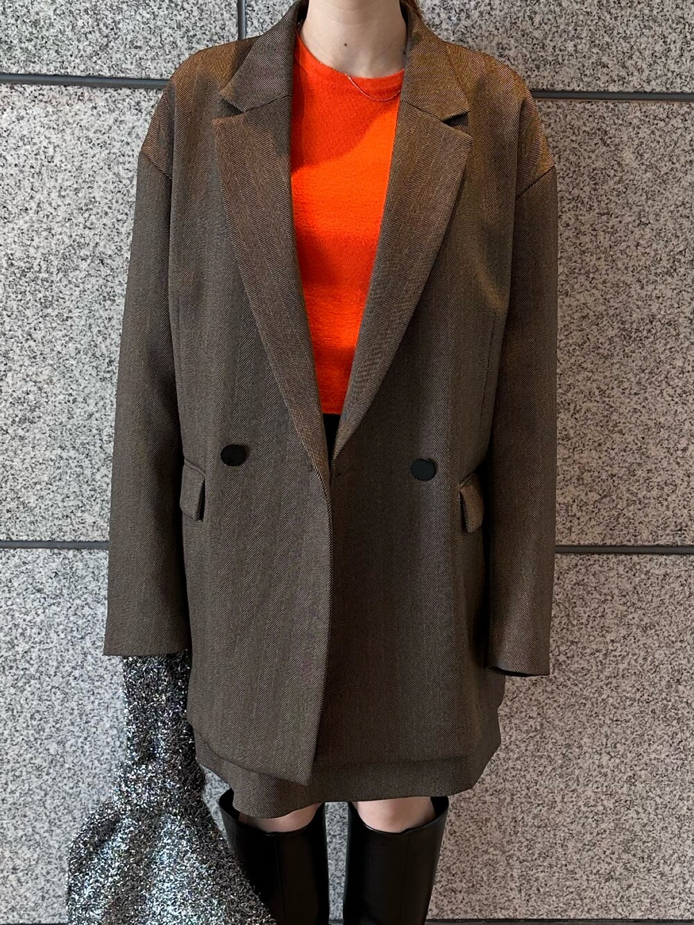 オレンジ系のニット/セーター、ブラウン系のテーラードジャケット、ブラウン系のスカートを着用したレディースの秋コーディネートの10枚目の写真