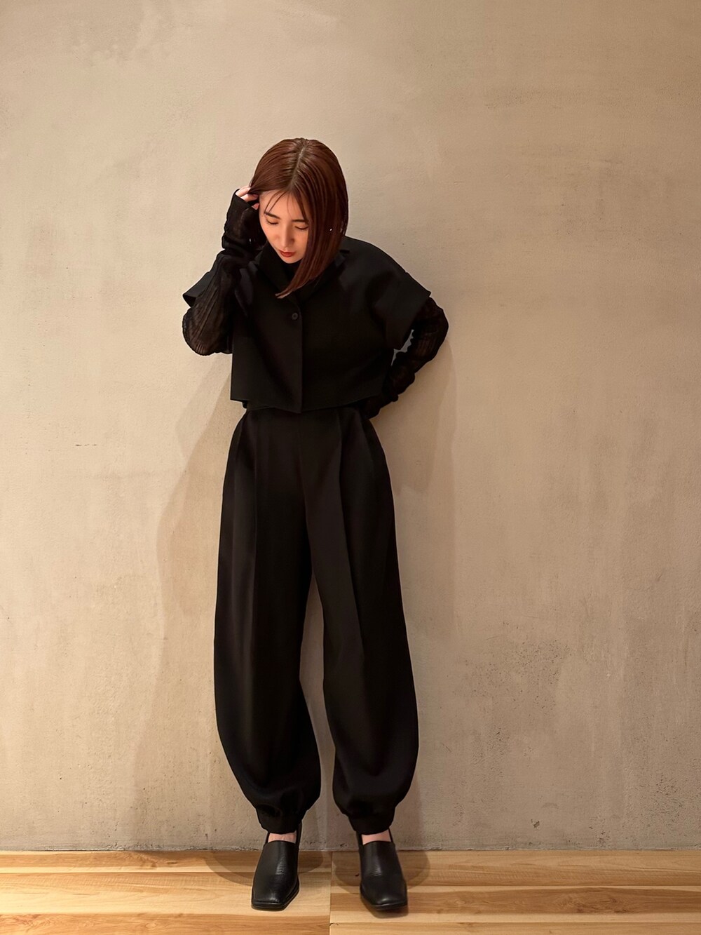 ブラック系のスラックス、ブラック系のニット/セーター、ブラック系のテーラードジャケットを着用したレディースの春コーディネートの8枚目の写真