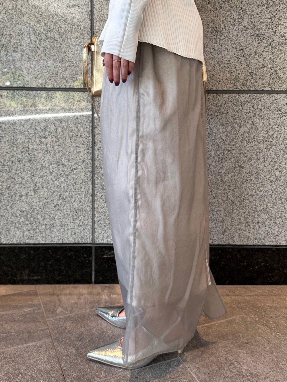 ホワイト系のカーディガン/ボレロ、ベージュ系のスカート、シルバー系のサンダルを着用したレディースの秋コーディネートの9枚目の写真