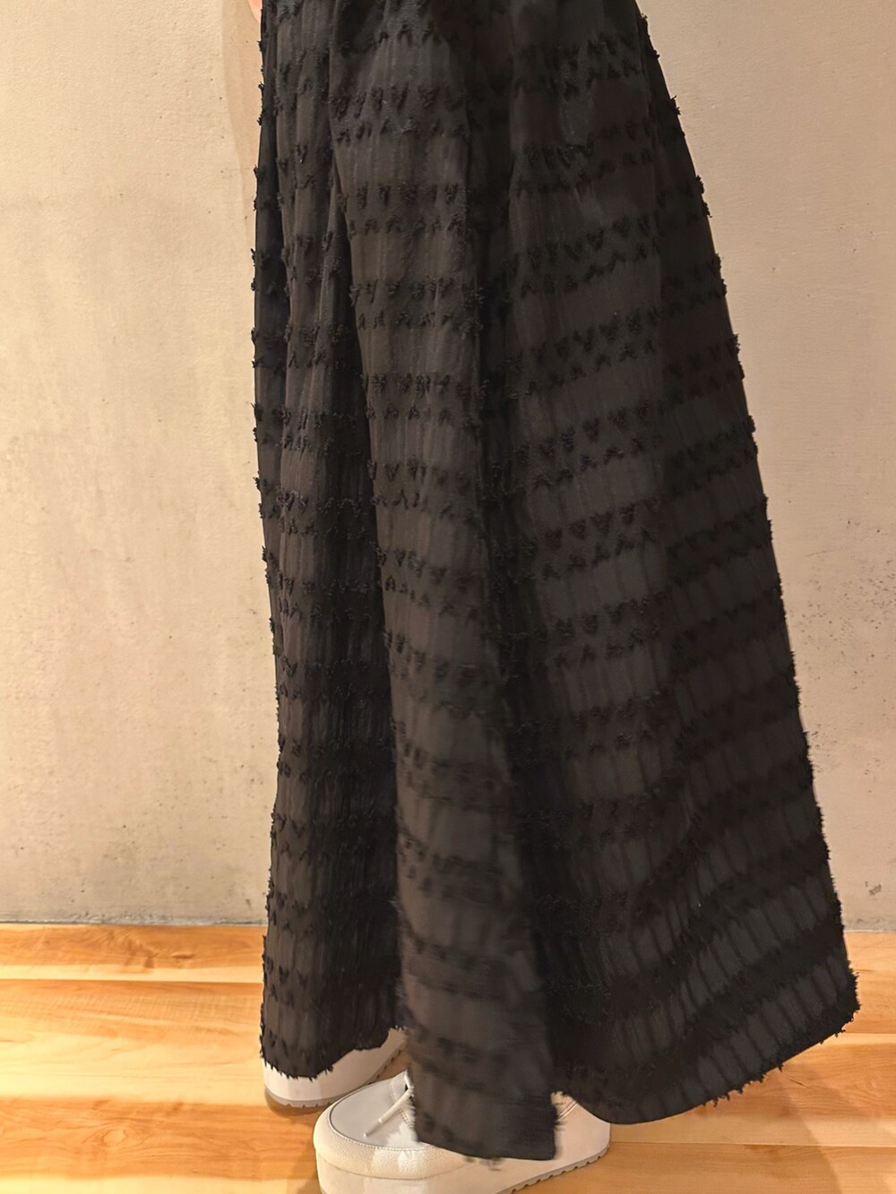 ブラック系のテーラードジャケット、ホワイト系のスニーカー、ブラック系のスカートを着用したレディースの春コーディネートの8枚目の写真