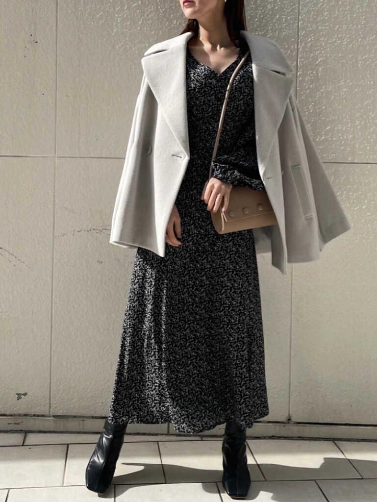 ベージュ系のハンドバッグ、ブラック系のワンピースを着用したレディースの冬コーディネートの3枚目の写真