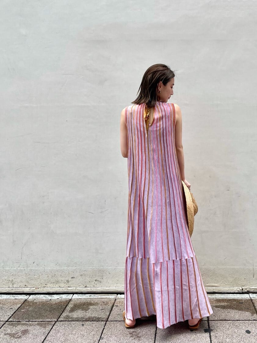 パープル系のワンピース、ベージュ系のハットを着用したレディースの夏コーディネートの3枚目の写真