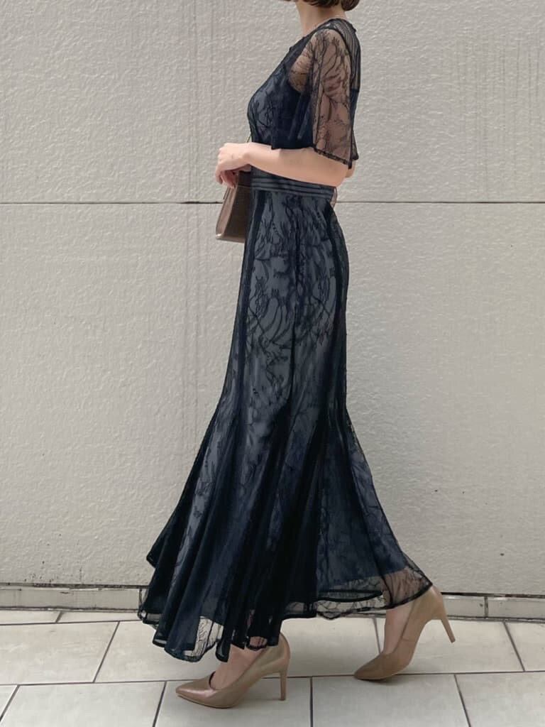 ゴールド系のパンプス、ゴールド系のクラッチバッグ、ブラック系のドレスを着用したレディースの春コーディネートの7枚目の写真
