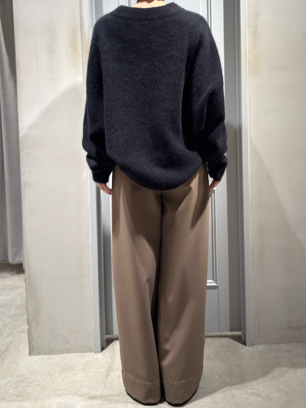 ブラック系のニット/セーター、ベージュ系のその他パンツ、その他のパンプスを着用したレディースの冬コーディネートの3枚目の写真