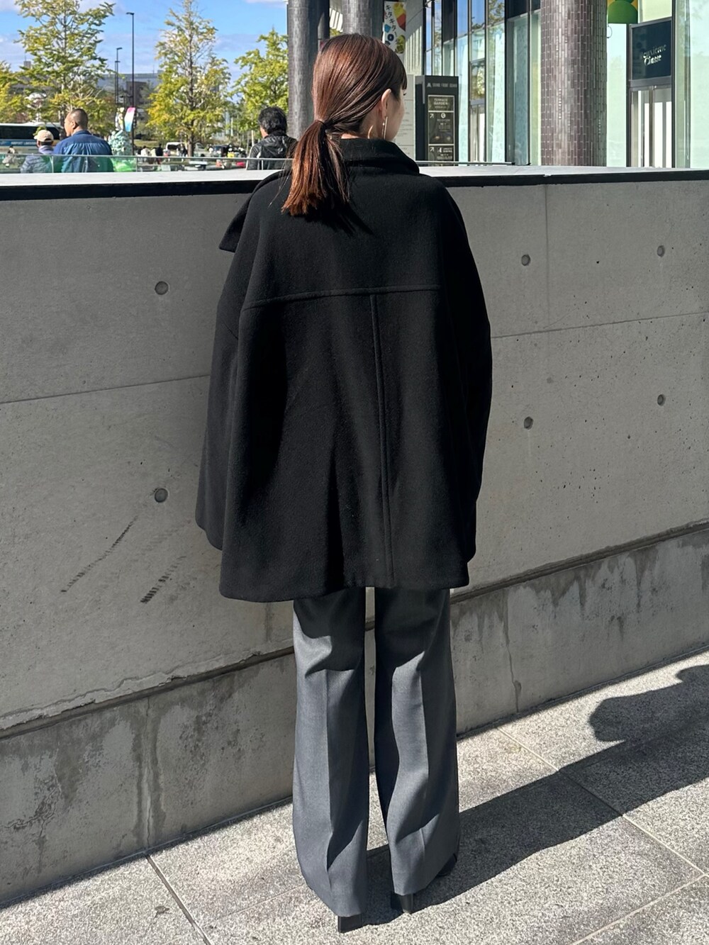 ブラック系のその他アウター、レッド系のニット/セーター、グレー系のその他パンツを着用したレディースの冬コーディネートの4枚目の写真