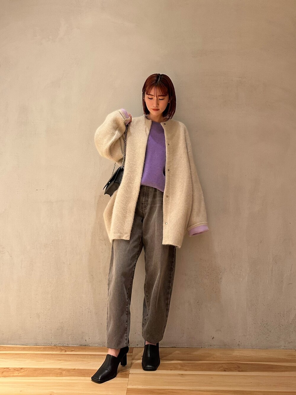 パープル系のニット/セーター、グレー系のデニムパンツ、ブラック系のパンプスを着用したレディースの夏コーディネートの5枚目の写真