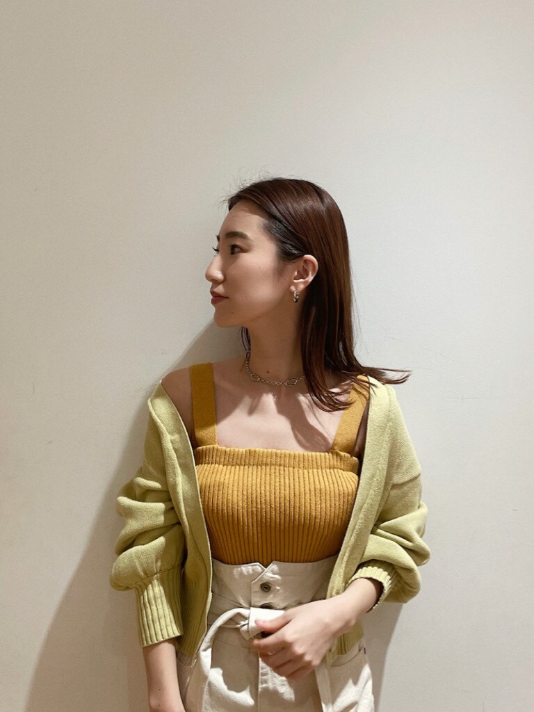 ホワイト系のデニムパンツ、ブラウン系のパンプス、パープル系のハンドバッグを着用したレディースの冬コーディネートの3枚目の写真