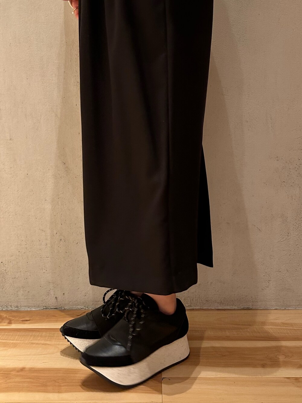 ホワイト系のTシャツ/カットソー、ブラック系のスカート、ブラック系のスニーカーを着用したレディースの冬コーディネートの7枚目の写真